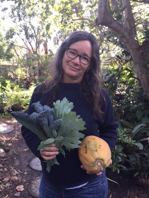 woman holding papaya and kale